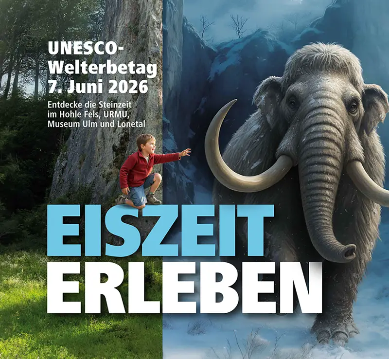 Ein Junge in rotem Pullover streckt die Hand zu einem großen Wollhaarmammut mit langen gebogenen Stoßzähnen in einer eiszeitlichen Waldlandschaft